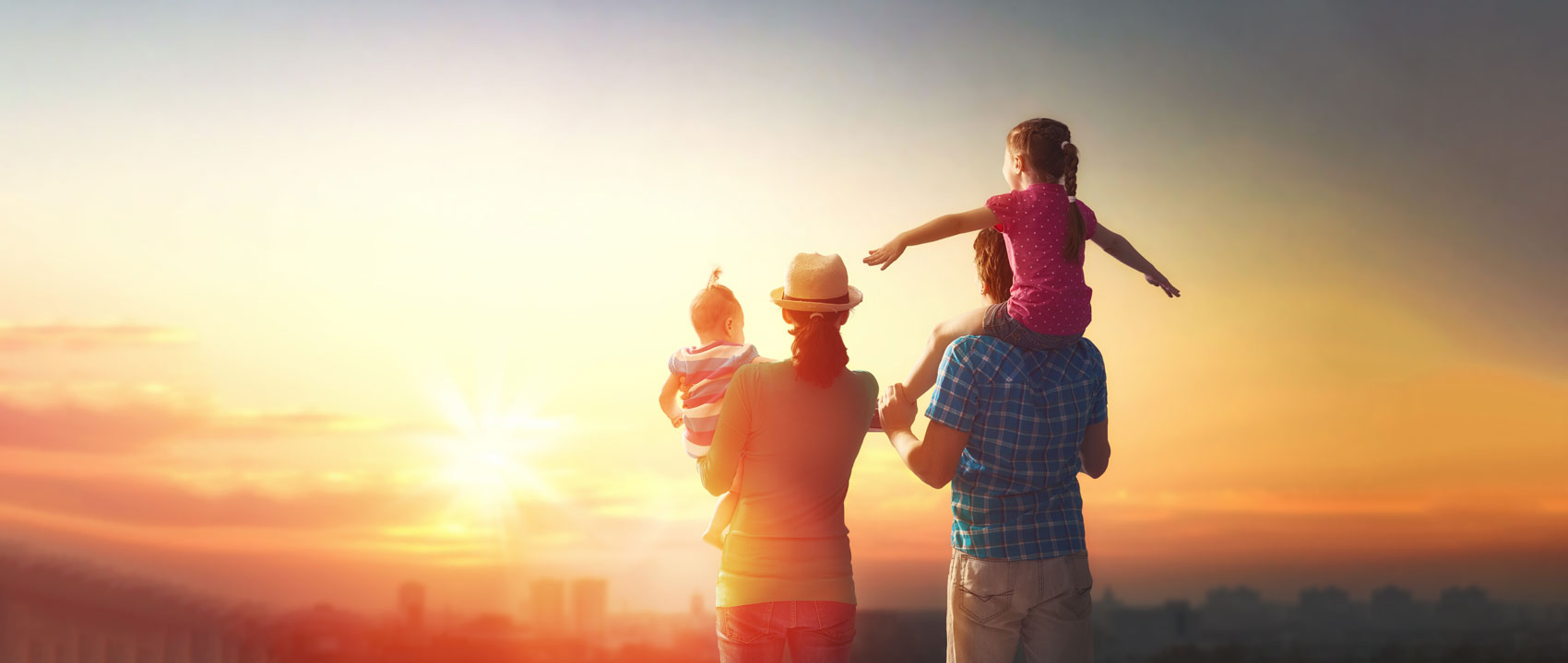 Papà con il figlio sulle spalle al tramonto